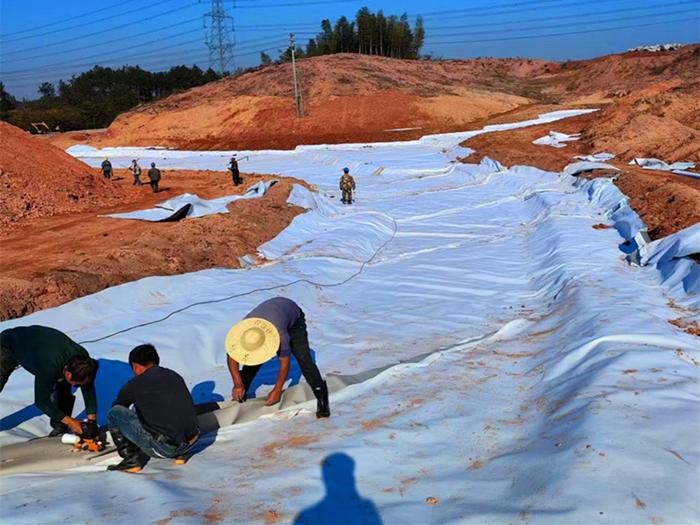 What is the purpose of laying composite geomembrane in a lotus pond?